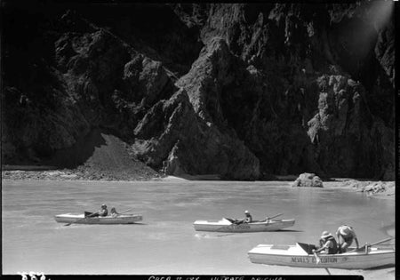 Black and white photo of passengers in small boats