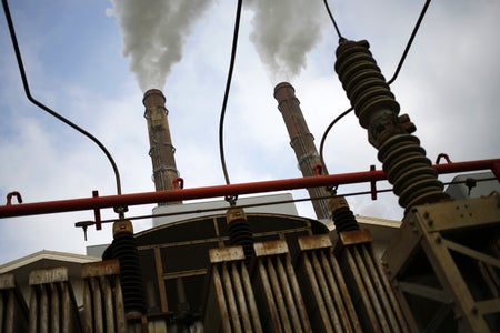 An electrical transformer stands behind a power plant in Kentucky